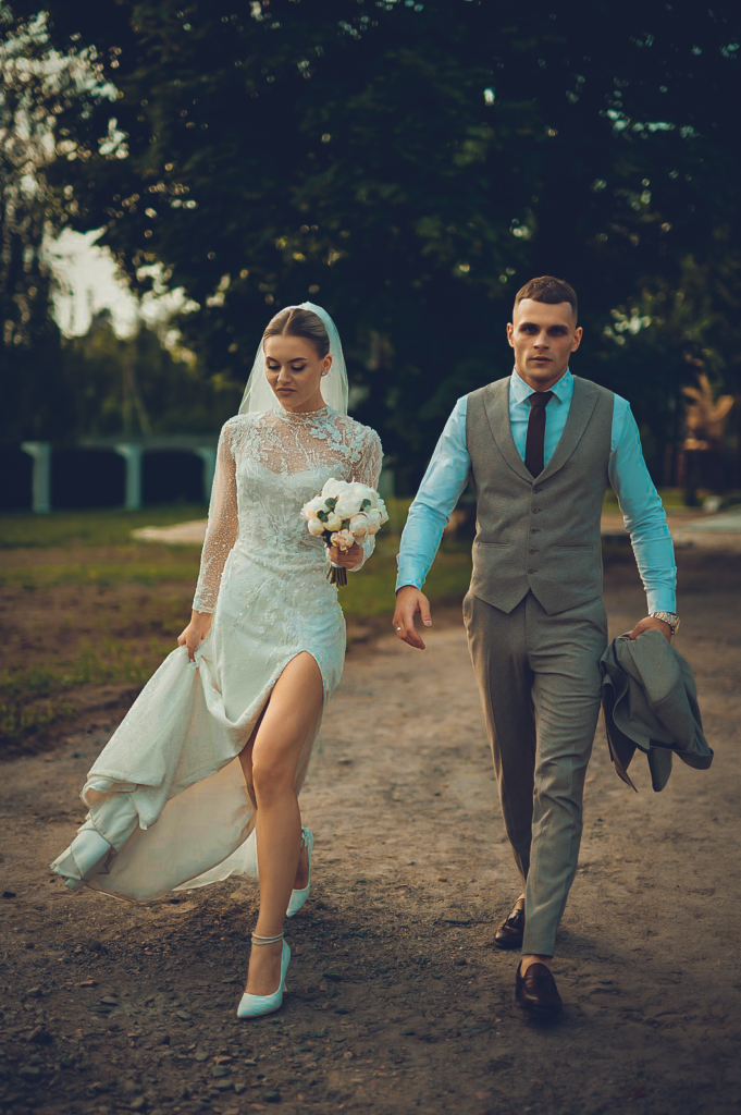 Wideofilmowanie ślubów i wesel -Piękna para młoda śmieje się podczas ceremonii ślubnej, uchwycona w chwili szczęścia i miłości pod otwartym niebem.